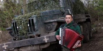 (Фото) Украински војник им свиреше на хармоника на колегите за да им го разубави денот