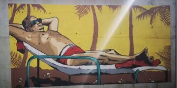 Мурал со Тито кој се сонча под палми во црвени гаќи осамна во Ровињ