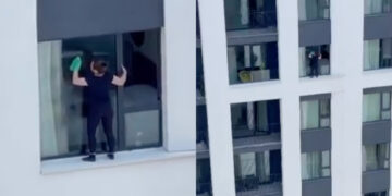 (Видео) Ќе ви се заледи крвта: Жена во Белград виси на облакодер, за да ги исчисти прозорците од надворешна страна