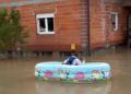 (Фото) Маж плови во детски базен и му носи кафе на комшијата по поплавите во Словенија и Хрватска